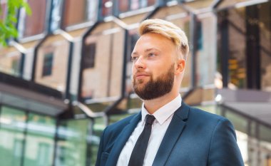 Modern ofis binasının önünde duran bir iş adamı. Dışarıdaki finans yatırımcısı. Bankacılık ve iş konsepti.