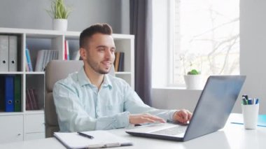 Genç adam evde bir bilgisayarın önünde otururken çalışıyor. Profesyonel bir işçinin, serbest çalışanın ya da öğrencinin işyeri. Mesafe Çalışma ve Eğitim Konsepti.