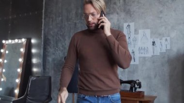 Genç ve yetenekli moda tasarımcılarının işyeri. Terzi şık çatı katında tek başına çalışıyor. Kıyafet çizimleri kullanıyor..