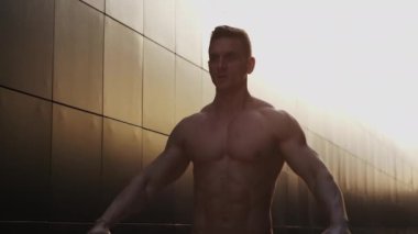 Sunset 'te spor yapan genç kaslı adam. Genç ve güçlü bir sporcunun eğitimi. Fitness ve Sağlıklı Yaşam Konsepti.