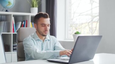 Genç Öğretmen evde bilgisayarın önünde otururken çevrimiçi ders veriyor. Profesyonel Okul Dersleri Öğretmeni 'nin İş Yeri. Uzaktan Eğitim ve Öğrenim Konsepti.
