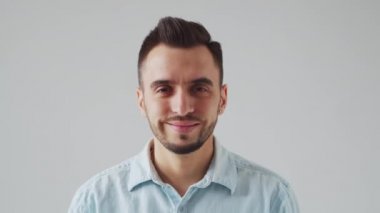 Genç Kafkas Brunet Sakallı Adam Açık Gri Arkaplan 'daki kameraya bakıyor. Stüdyo Erkek Yüz Portresi. Doğal Gün Işığı.