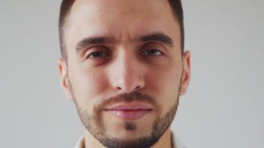 Genç Kafkas Brunet Sakallı Adam Açık Gri Arkaplan 'daki kameraya bakıyor. Stüdyo Erkek Yüz Portresi. Doğal Gün Işığı.