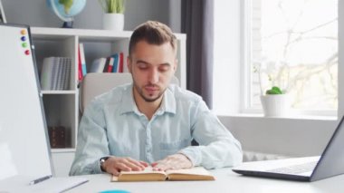 Genç Öğretmen evde bilgisayarın önünde otururken çevrimiçi ders veriyor. Profesyonel Okul Dersleri Öğretmeni 'nin İş Yeri. Uzaktan Eğitim ve Öğrenim Konsepti.