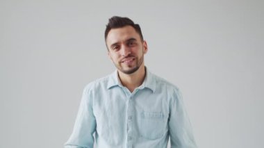 Genç Kafkas Brunet Sakallı Adam Açık Gri Arkaplan 'daki kameraya bakıyor. Stüdyo Erkek Yüz Portresi. Doğal Gün Işığı.