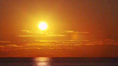 Timelapse with Sunset and Cumulus Clouds Flying High in a Beautiful Blue Sky. Sun Dawn in the Sea. Concept of Weather, Climate Change and Global Warming.