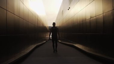 Sunset 'te spor yapan genç kaslı adam. Genç ve güçlü bir sporcunun eğitimi. Fitness ve Sağlıklı Yaşam Konsepti.