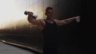 Sunset 'te spor yapan genç kaslı adam. Genç ve güçlü bir sporcunun eğitimi. Fitness ve Sağlıklı Yaşam Konsepti.