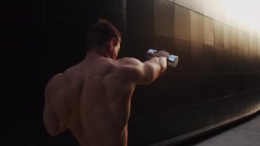 Sunset 'te spor yapan genç kaslı adam. Genç ve güçlü bir sporcunun eğitimi. Fitness ve Sağlıklı Yaşam Konsepti.