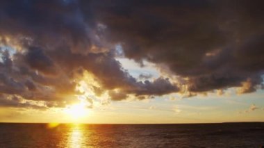 Timelapse with Sunset and Cumulus Clouds Flying High in a Beautiful Blue Sky. Sun Dawn over the Sea. Concept of Weather, Climate Change and Global Warming.