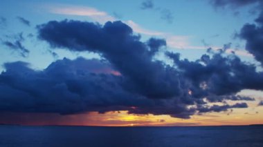 Timelapse with Sunset and Cumulus Clouds Flying High in a Beautiful Blue Sky. Sun Dawn over the Sea. Concept of Weather, Climate Change and Global Warming.