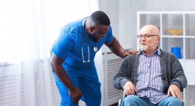 Profesyonel doktor kronik hastalıkları olan yaşlı bir adama yardım ediyor. İç işlerinde terapist ve hasta var. Sağlık ve ilaç kavramı.