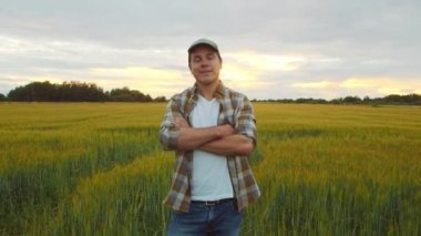 Günbatımı tarımının önündeki çiftçi. Kırsal kesimde bir adam. Kır hayatı, gıda üretimi, tarım ve kırsal yaşam tarzı kavramı.