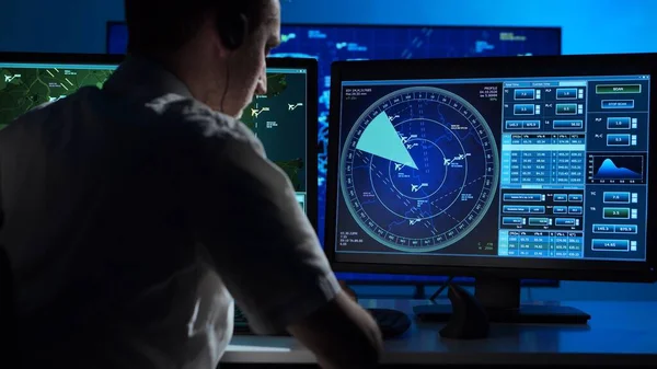 Workplace of the professional air traffic controller in the control tower. Caucasian aircraft control officer works using radar, computer navigation and digital maps. Aviation and technology concept.