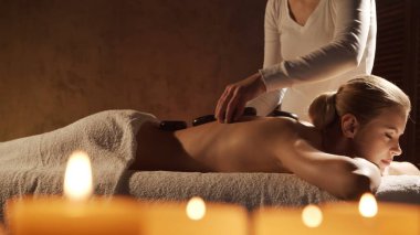 Genç, sağlıklı ve güzel bir kadın spa salonunda masaj terapisi görüyor. Sağlıklı yaşam tarzı ve vücut bakımı kavramı.