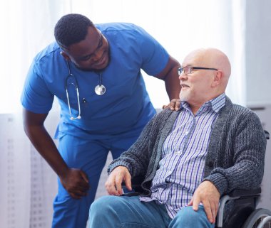 Profesyonel doktor kronik hastalıkları olan yaşlı bir adama yardım ediyor. İç işlerinde terapist ve hasta var. Sağlık ve ilaç kavramı.