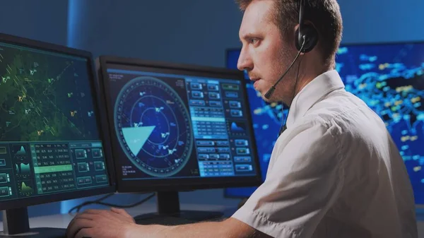 Workplace of the professional air traffic controller in the control tower. Caucasian aircraft control officer works using radar, computer navigation and digital maps. Aviation and technology concept.