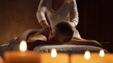 Genç, sağlıklı ve güzel bir kadın spa salonunda masaj terapisi görüyor. Sağlıklı yaşam tarzı ve vücut bakımı kavramı.