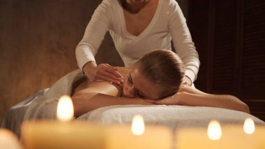 Genç, sağlıklı ve güzel bir kadın spa salonunda masaj terapisi görüyor. Sağlıklı yaşam tarzı ve vücut bakımı kavramı.