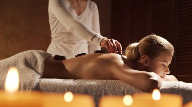 Genç, sağlıklı ve güzel bir kadın spa salonunda masaj terapisi görüyor. Sağlıklı yaşam tarzı ve vücut bakımı kavramı.