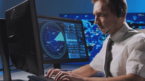 Workplace of the professional air traffic controller in the control tower. Caucasian aircraft control officer works using radar, computer navigation and digital maps. Aviation and technology concept.