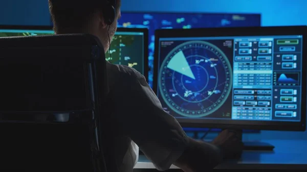 Workplace of the professional air traffic controller in the control tower. Caucasian aircraft control officer works using radar, computer navigation and digital maps. Aviation and technology concept.