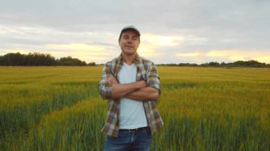 Günbatımı tarımının önündeki çiftçi. Kırsal kesimde bir adam. Kır hayatı, gıda üretimi, tarım ve kırsal yaşam tarzı kavramı.