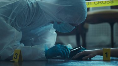 Detective Collecting Evidence in a Crime Scene. Forensic Specialists Making Expertise at Home of a Dead Person. The Concept of Homicide Investigation by Professional Police Officer.