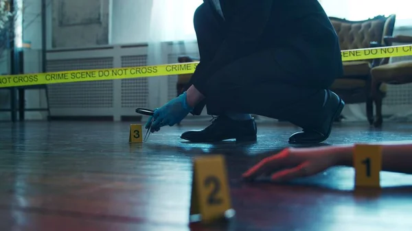 Detective Collecting Evidence in a Crime Scene. Forensic Specialists Making Expertise at Home of a Dead Person. The Concept of Homicide Investigation by Professional Police Officer.