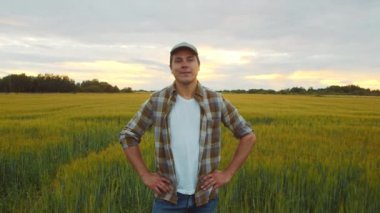 Günbatımı tarımının önündeki çiftçi. Kırsal kesimde bir adam. Kır hayatı, gıda üretimi, tarım ve kırsal yaşam tarzı kavramı.