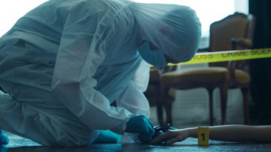 Detective Collecting Evidence in a Crime Scene. Forensic Specialists Making Expertise at Home of a Dead Person. The Concept of Homicide Investigation by Professional Police Officer.