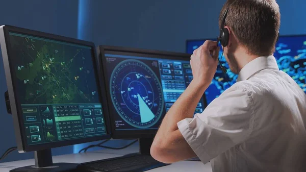 Workplace of the professional air traffic controller in the control tower. Caucasian aircraft control officer works using radar, computer navigation and digital maps. Aviation and technology concept.