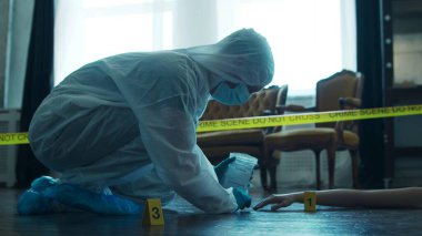 Detective Collecting Evidence in a Crime Scene. Forensic Specialists Making Expertise at Home of a Dead Person. The Concept of Homicide Investigation by Professional Police Officer.