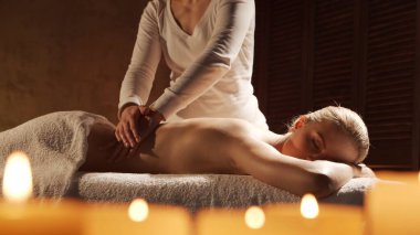 Genç, sağlıklı ve güzel bir kadın spa salonunda masaj terapisi görüyor. Sağlıklı yaşam tarzı ve vücut bakımı kavramı.