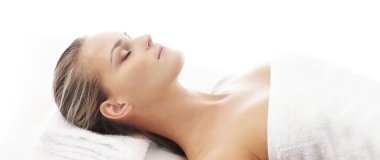 Genç, güzel ve sağlıklı bir kadın spa salonunda. Geleneksel masaj terapisi ve cilt bakımı. Sağlık ve eğlence konsepti.