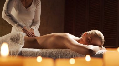 Genç, sağlıklı ve güzel bir kadın spa salonunda masaj terapisi görüyor. Sağlıklı yaşam tarzı ve vücut bakımı kavramı.
