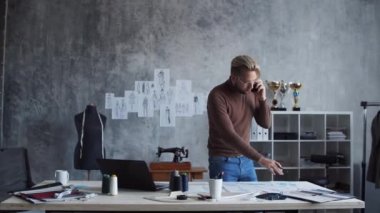 Genç ve yetenekli moda tasarımcılarının işyeri. Terzi şık çatı katında tek başına çalışıyor. Kıyafet çizimleri kullanıyor..