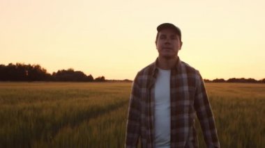 Günbatımı tarımının önündeki çiftçi. Kırsal kesimde bir adam. Kır hayatı, gıda üretimi, tarım ve kırsal yaşam tarzı kavramı.