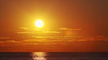 Timelapse with Sunset and Cumulus Clouds Flying High in a Beautiful Blue Sky. Sun Dawn in the Sea. Concept of Weather, Climate Change and Global Warming.