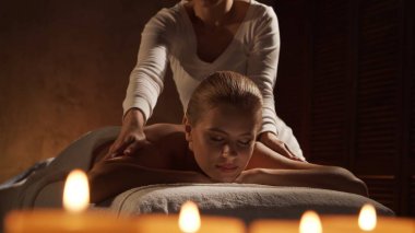 Genç, sağlıklı ve güzel bir kadın spa salonunda masaj terapisi görüyor. Sağlıklı yaşam tarzı ve vücut bakımı kavramı.