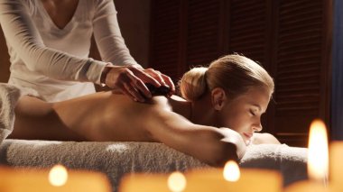 Genç, sağlıklı ve güzel bir kadın spa salonunda masaj terapisi görüyor. Sağlıklı yaşam tarzı ve vücut bakımı kavramı.