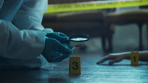 Detective Collecting Evidence in a Crime Scene. Forensic Specialists Making Expertise at Home of a Dead Person. The Concept of Homicide Investigation by Professional Police Officer.