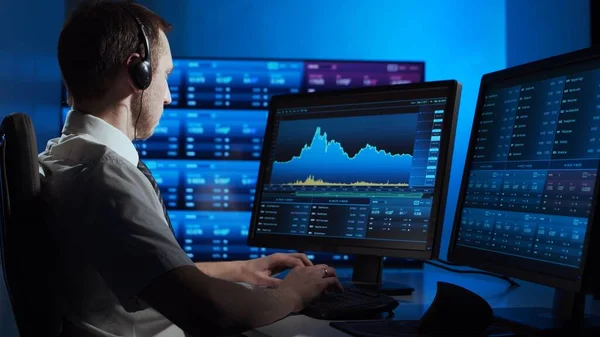 Broker works in office using workstation and analysis technology. Workplace of professional trader. Global financial markets, business strategy, currency exchange and banking concepts.