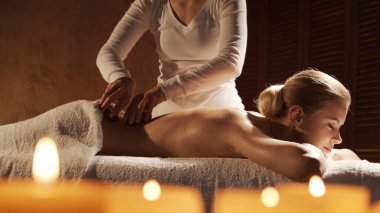 Genç, sağlıklı ve güzel bir kadın spa salonunda masaj terapisi görüyor. Sağlıklı yaşam tarzı ve vücut bakımı kavramı.