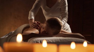 Genç, sağlıklı ve güzel bir kadın spa salonunda masaj terapisi görüyor. Sağlıklı yaşam tarzı ve vücut bakımı kavramı.