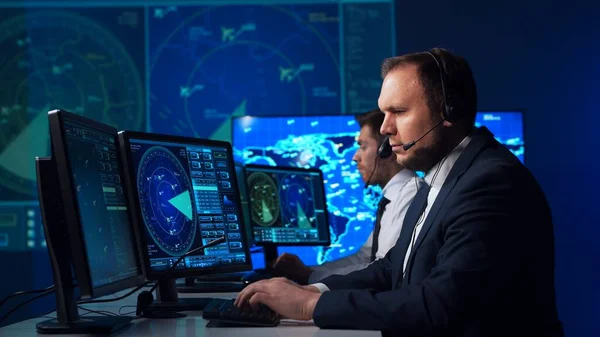 Workplace of the air traffic controllers in the control tower. Team of professional aircraft control officers works using radar, computer navigation and digital maps. The concept of aviation.