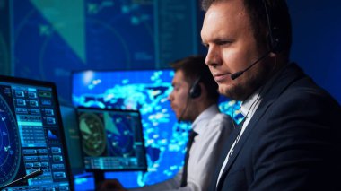 Workplace of the air traffic controllers in the control tower. Team of professional aircraft control officers works using radar, computer navigation and digital maps. The concept of aviation.