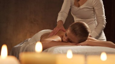 Genç, sağlıklı ve güzel bir kadın spa salonunda masaj terapisi görüyor. Sağlıklı yaşam tarzı ve vücut bakımı kavramı.