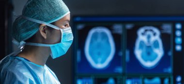 Diverse team of professional medical surgeons perform surgery in the operating room using high-tech equipment. Doctors work to save a patient in a modern hospital. The concept of medicine, technology
