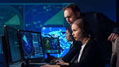 Workplace of the air traffic controllers in the control tower. Team of professional aircraft control officers works using radar, computer navigation and digital maps. The concept of aviation.